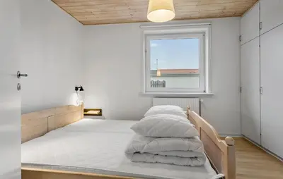 a bedroom with a bed with white sheets and a window at 4 Bedroom Awesome Home In Thisted in Thisted