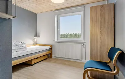 a small bedroom with a bed and a window at 4 Bedroom Awesome Home In Thisted in Thisted