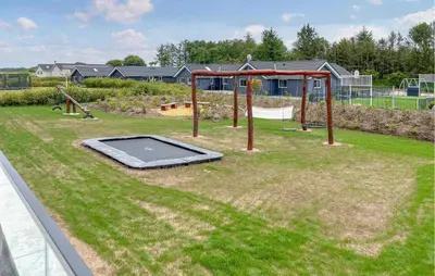 a playground with a trampoline in the grass at Stunning Home In Spøttrup With Sauna in Spottrup