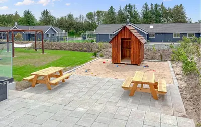 a backyard with two picnic tables and a play structure at Stunning Home In Spøttrup With Sauna in Spottrup