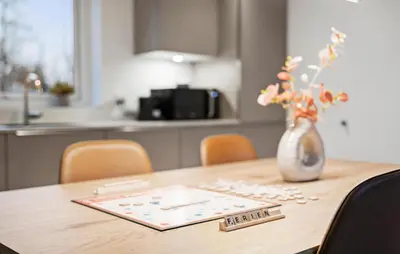 a wooden table with a vase with flowers on it at 2 Bedroom Pet Friendly Home In Vemb in Vemb