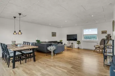 a dining room and living room with a table and a couch at Lovely Holiday Home, Renovated In 2024, Located In Hanstholm By The North Sea in Hanstholm