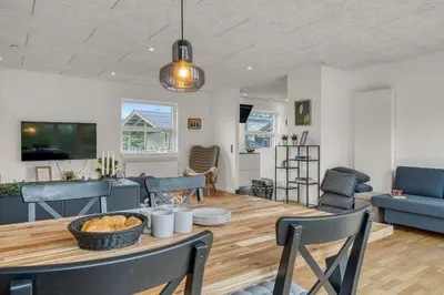 a dining room and living room with a table and chairs at Lovely Holiday Home, Renovated In 2024, Located In Hanstholm By The North Sea in Hanstholm