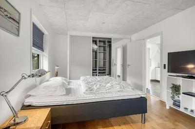 a bedroom with a bed and a desk and a tv at Lovely Holiday Home, Renovated In 2024, Located In Hanstholm By The North Sea in Hanstholm