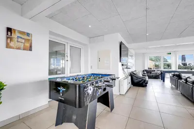 a living room with a pool table in the middle at 40-Person Holiday Home, With Large Pool Area And Panoramic Views Of The Limfjord in Thyholm