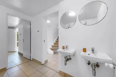 a bathroom with two sinks and two mirrors at 40-Person Holiday Home, With Large Pool Area And Panoramic Views Of The Limfjord in Thyholm