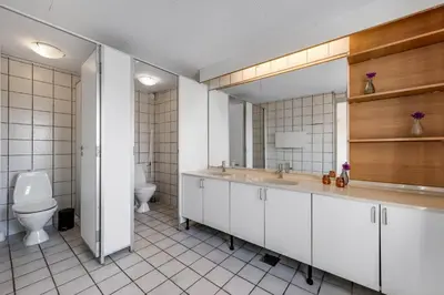 a bathroom with a toilet and a sink and a mirror at 40-Person Holiday Home, With Large Pool Area And Panoramic Views Of The Limfjord in Thyholm