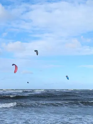 a group of kites flying in the sky over the ocean at Hyggeligt feriehus in Thisted
