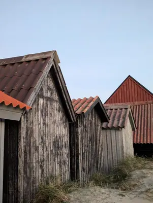 an old wooden fence with a red roof at Hyggeligt feriehus in Thisted