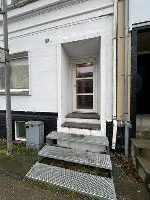 a white house with stairs leading to a door at Perfect space for you and your colleague in Vinderup