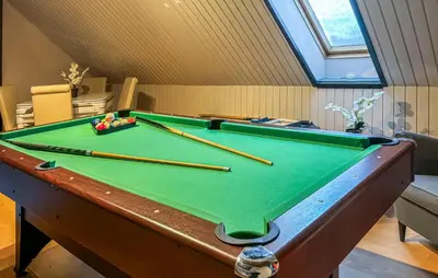 a pool table with cuesticks on top of it at Awesome Home In Øster Assels With Wifi in Øster Assels