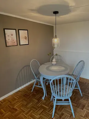 a dining room table with three chairs and a ceiling at Gæstehuset Husly in Haderup