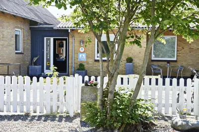a white picket fence in front of a house at Hostel Agger Vandrerhjem in Agger