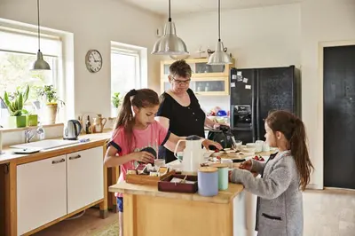 a woman and two girls in a kitchen preparing food at Hostel Agger Vandrerhjem in Agger