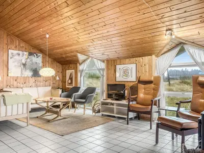 a living room with wooden walls and a wooden ceiling at Holiday Home Annemone - 600m from the sea by Interhome in Torsted