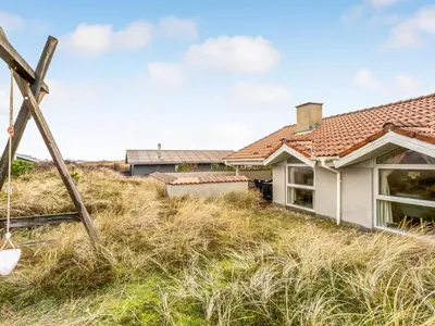 a house on top of a hill with tall grass at Holiday Home Annemone - 600m from the sea by Interhome in Torsted