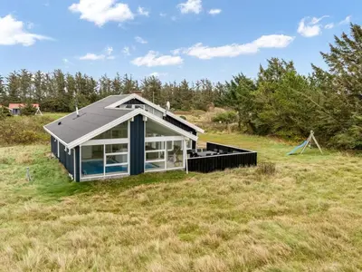 a small house with a solar roof on a field at Holiday Home Caya - 750m from the sea by Interhome in Løkken