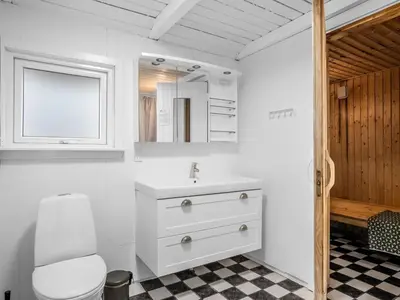 a white bathroom with a sink and a mirror at Holiday Home Caya - 750m from the sea by Interhome in Løkken