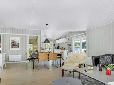a living room and kitchen with a table and chairs at Holiday Home Quiana - 2km from the sea by Interhome in Pandrup