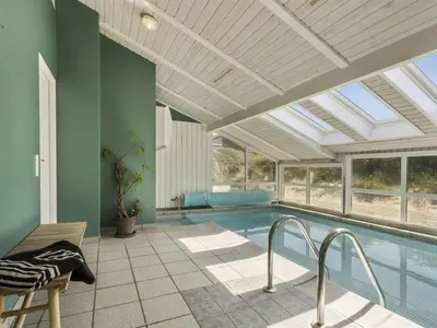 a swimming pool in a house with a ceiling at Holiday Home Erma - 125m from the sea by Interhome in Saltum