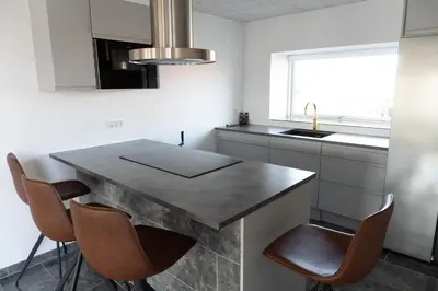 a kitchen with a table with chairs and a sink at Birkelse Hotel og Kro in Birkelse