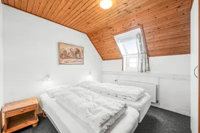 two beds in a bedroom with a wooden ceiling at Family-Friendly Holiday Home With Pool, Located Close To The North Sea In Vrist in Harboør