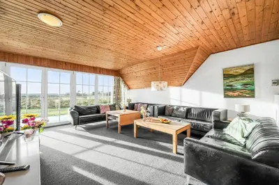 a living room with leather furniture and a wooden ceiling at Family-Friendly Holiday Home With Pool, Located Close To The North Sea In Vrist in Harboør