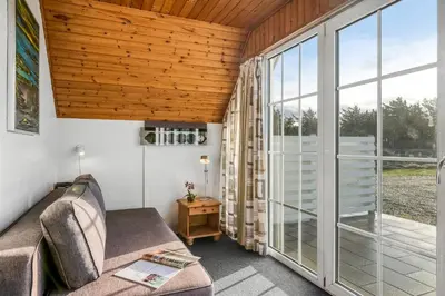 a living room with a couch and a large window at Family-Friendly Holiday Home With Pool, Located Close To The North Sea In Vrist in Harboør