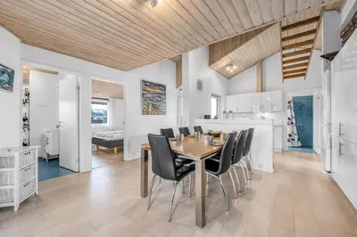 a dining room with a table and black chairs at Lovely Holiday Home With Pool, Spa And Sauna, Only 200 Meters From The North Sea in Harboør