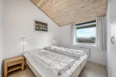 a bedroom with two beds and a window at Lovely Holiday Home With Pool, Spa And Sauna, Only 200 Meters From The North Sea in Harboør