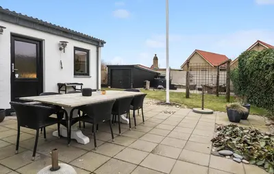 a patio with a table and chairs in a backyard at Cozy Home In Thyborøn With Wifi in Thyborøn