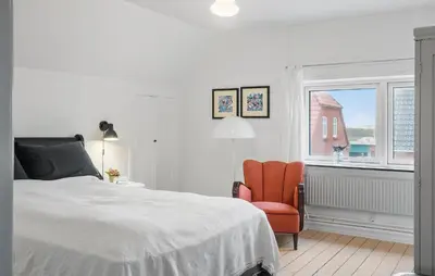 a bedroom with a bed and a chair and a window at Cozy Home In Thyborøn With Wifi in Thyborøn