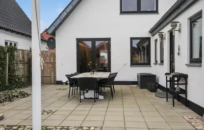 a patio with a table and chairs next to a house at Cozy Home In Thyborøn With Wifi in Thyborøn