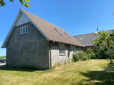an old building with a brown roof on a yard at Jørgen's Feriehus in Lemvig
