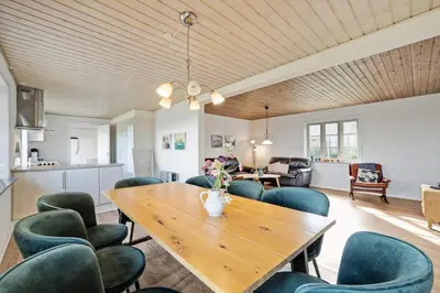 a dining room with a wooden table and chairs at Jørgen's Feriehus in Lemvig