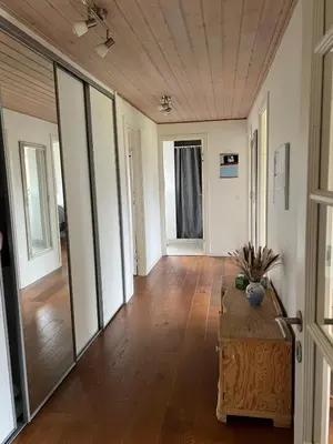 a living room with a table and a large mirror at Dejlig og hyggelig hus i Thyborøn in Thyborøn