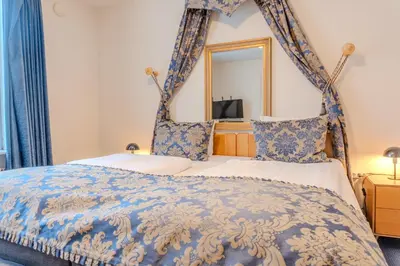 a bedroom with a canopy bed with a mirror at Hotel Palads Apartments in Viborg