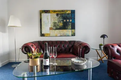 a living room with a couch and a glass table at Hotel Palads Apartments in Viborg