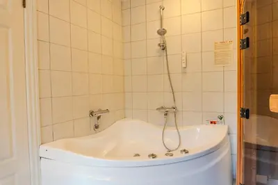 a bath tub with a shower in a bathroom at Hotel Palads Apartments in Viborg