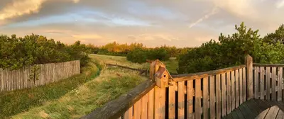 a wooden fence in a field with a sky at Vesterhavsluft Og Natur Ved Nationalpark Thy in Thisted