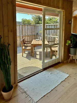 a sliding glass door of a deck with a table at Vesterhavsluft Og Natur Ved Nationalpark Thy in Thisted