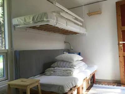 a room with a bunk bed with white pillows at Summer House In The Dunes Near The West Sea in Saltum