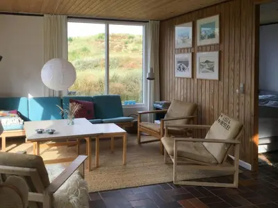 a living room with a couch and chairs and a table at Summer House In The Dunes Near The West Sea in Saltum