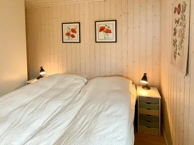 a bedroom with a white bed and two pictures on the wall at Stunning Sunrises Over Harre Vig in Roslev