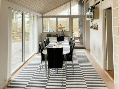 a dining room with a table and black chairs at Stunning Sunrises Over Harre Vig in Roslev