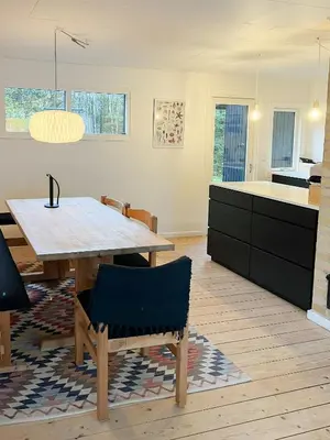 a kitchen and dining room with a wooden table at Nature-Rich Oasis With Views Over The Limfjord in Roslev