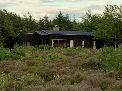 a house with a black roof in a field at Nature-Rich Oasis With Views Over The Limfjord in Roslev