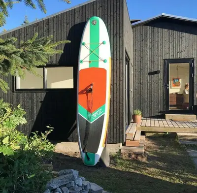 a surfboard is sitting outside of a house at Nature-Rich Oasis With Views Over The Limfjord in Roslev
