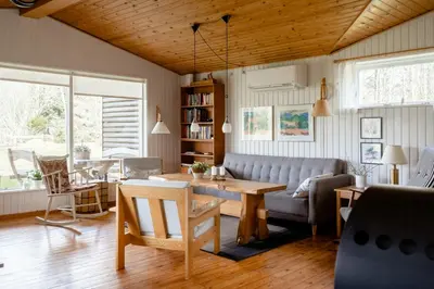 a living room with a couch and a table at Authentic Family Summer House At The Limfjord in Roslev