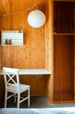 a wooden wall with a white desk and a chair at Authentic Family Summer House At The Limfjord in Roslev